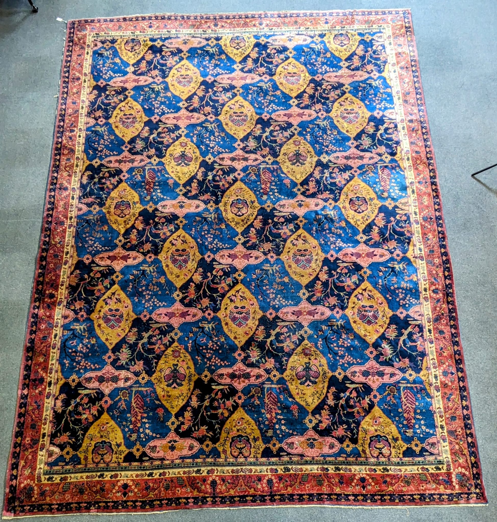 A Khorasan Mashhad red ground carpet, circa 1930’s, with field of stylised floral motif medallions, multi-bordered, 545 x 400cm. Condition - fair